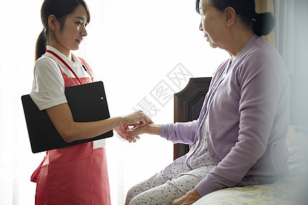 专业护理员给独居老妇人测量脉搏图片