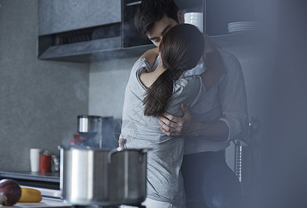 厨房里拥抱接吻的情侣图片