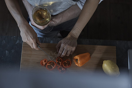 端着酒杯的男人搂着切菜的女人图片