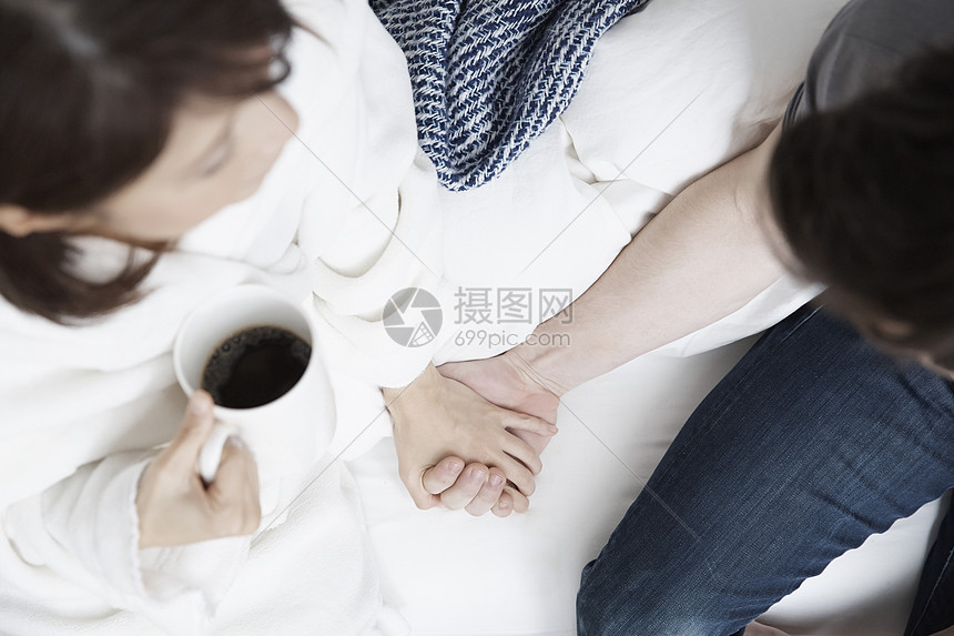 女人端着杯子握着男人的手图片