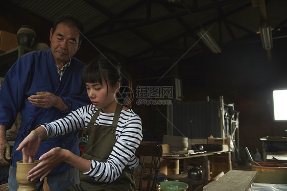 陶瓷师傅指导体验陶瓷制作的女人图片