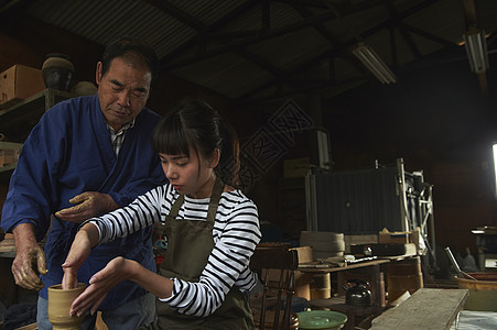 陶瓷师傅指导体验陶瓷制作的女人图片