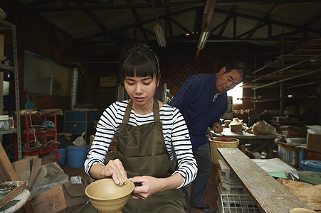 陶瓷师傅指导体验陶瓷制作的女人图片