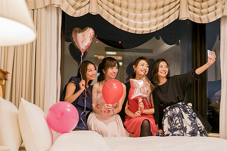朋友聚会女人们在卧室拿着气球自拍图片