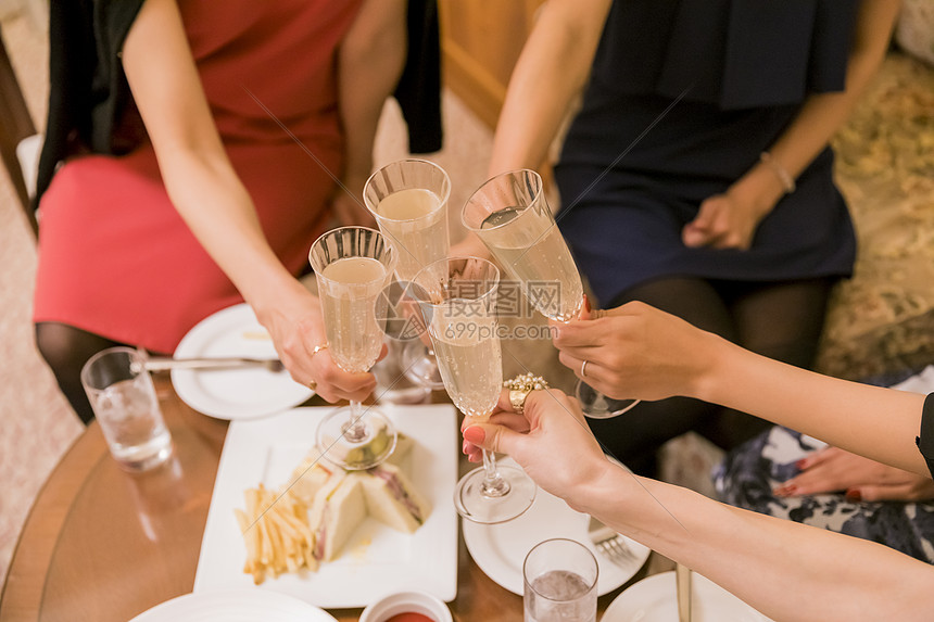 朋友聚会女人们在桌边聊天说笑碰杯
