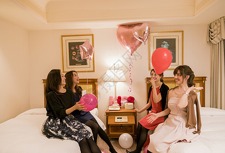 朋友聚会女人们在卧室拿着气球说笑图片