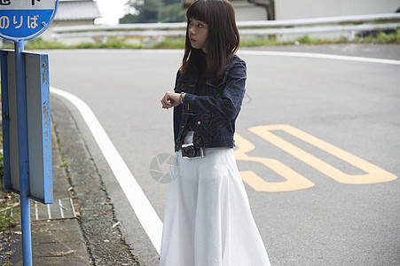 女子路边看时间背景图片