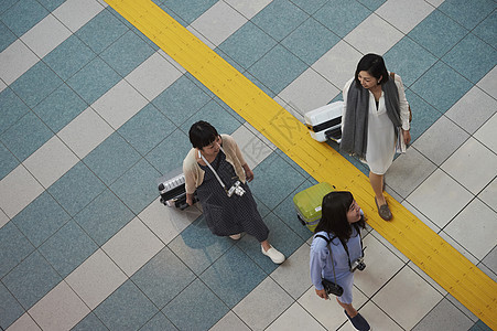 拉着行李走在航空站的女人们图片