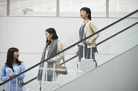 在航空站楼梯上带着行李的女人们图片