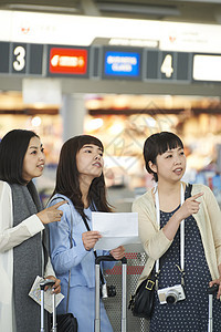 在航空站带着行李的女人们在看说明图片