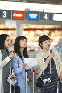 在航空站带着行李的女人们在看说明图片