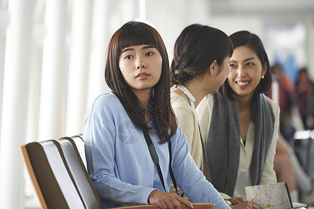 带着行李坐在航空站候车室的女人们图片