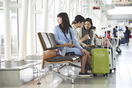 带着行李坐在航空站候车室的女人们图片