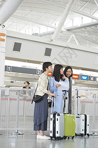 带着行李坐在航空站候车室的女人们图片