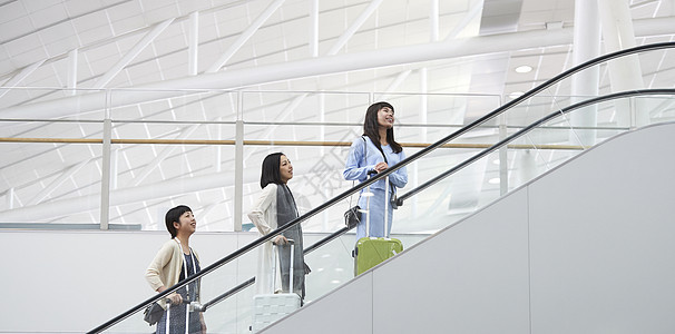 带着行李站在航空站扶梯上的女人们图片