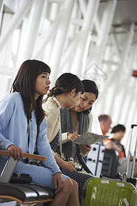 带着行李坐在航空站候车室的女人们图片