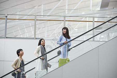 带着行李站在航空站扶梯上的女人们图片