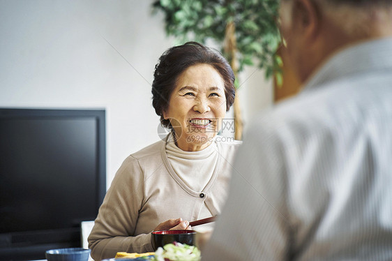 老人吃饭与朋友交谈图片