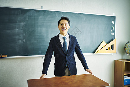 在黑板前看着镜头微笑的老师图片素材