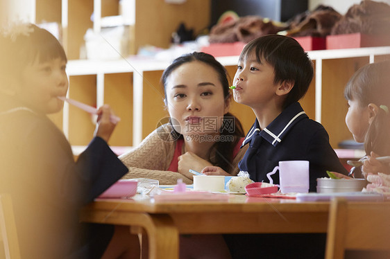 在午餐时间老师看着小朋友吃饭图片