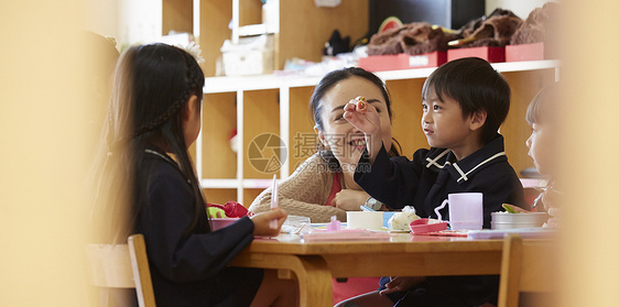 老师监督幼儿园小朋友吃午餐图片