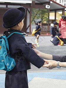 妈妈背孩子和母亲告别的小学生背景