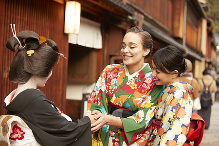 穿着和服与艺伎握手的外国游客图片