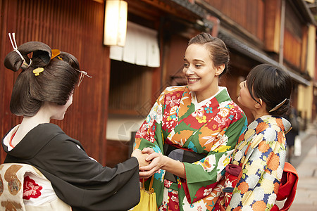 穿着和服与艺伎握手的外国游客图片