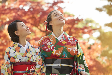 茶屋町穿着和服的女人站在枫叶前图片