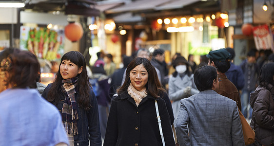 在街上人流中穿行的女游客宫岛图片