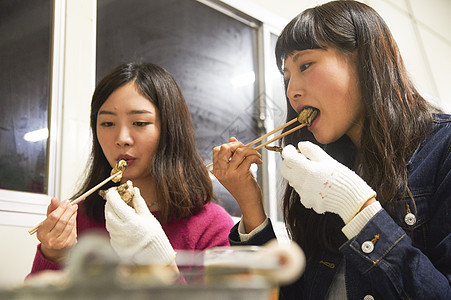 两个女人在吃烤生蚝图片