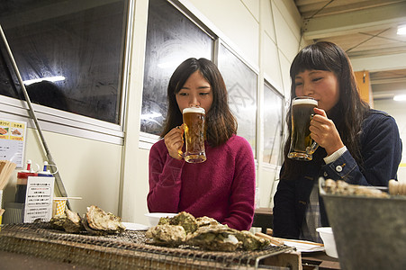 两个女人在吃烧烤喝啤酒图片