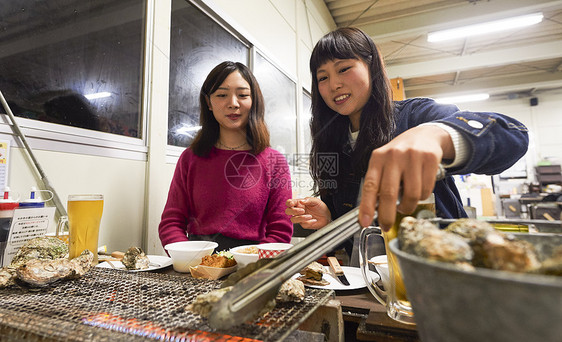 两个女人在烤生蚝图片