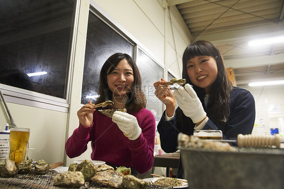 两个女人在吃烤生蚝图片