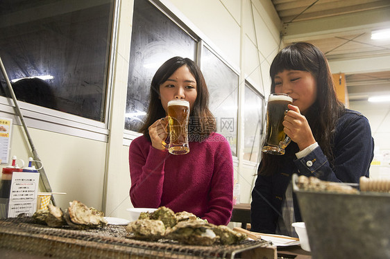 两个女人在吃烧烤喝啤酒图片