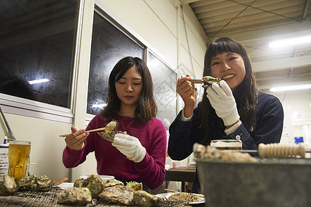 两个女人在吃烤生蚝图片