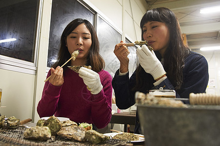 两个女人在吃烤生蚝图片