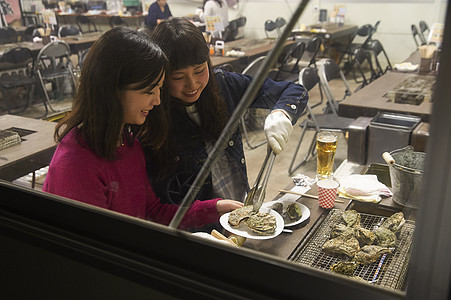 两个女人在烤生蚝图片