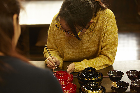 体验漆器制作的女人背景图片