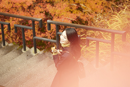 年轻女人观赏秋天枫叶图片
