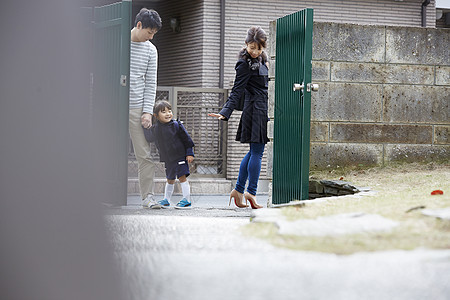 爸爸牵着小孩正在和妈妈挥手告别图片