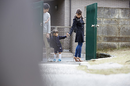 爸爸牵着小孩正在和妈妈挥手告别图片