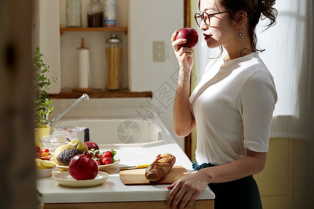 在窗边料理台制作午饭的女人图片