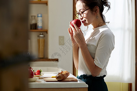 在窗边料理台制作午饭的女人图片