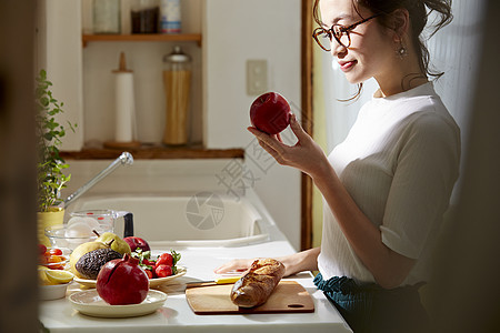 在窗边料理台制作午饭的女人背景图片