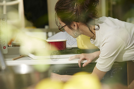 在窗边料理台制作午饭的女人图片