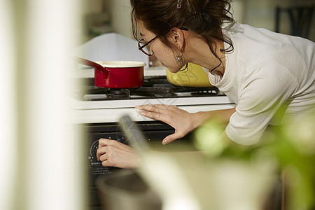 在窗边料理台制作午饭的女人图片