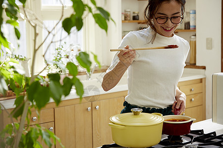 在窗边料理台制作午饭的女人图片