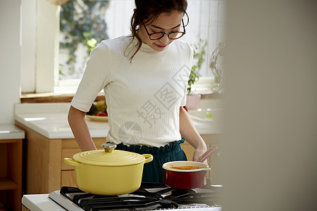 在窗边料理台制作午饭的女人图片