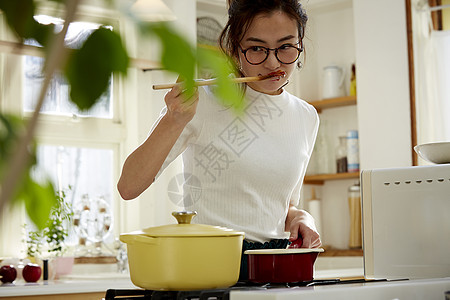 居家的美女正在品尝菜品口味图片